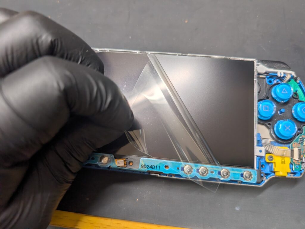 PSP3000に新しい液晶表面の保護シートを剥がしている時の写真