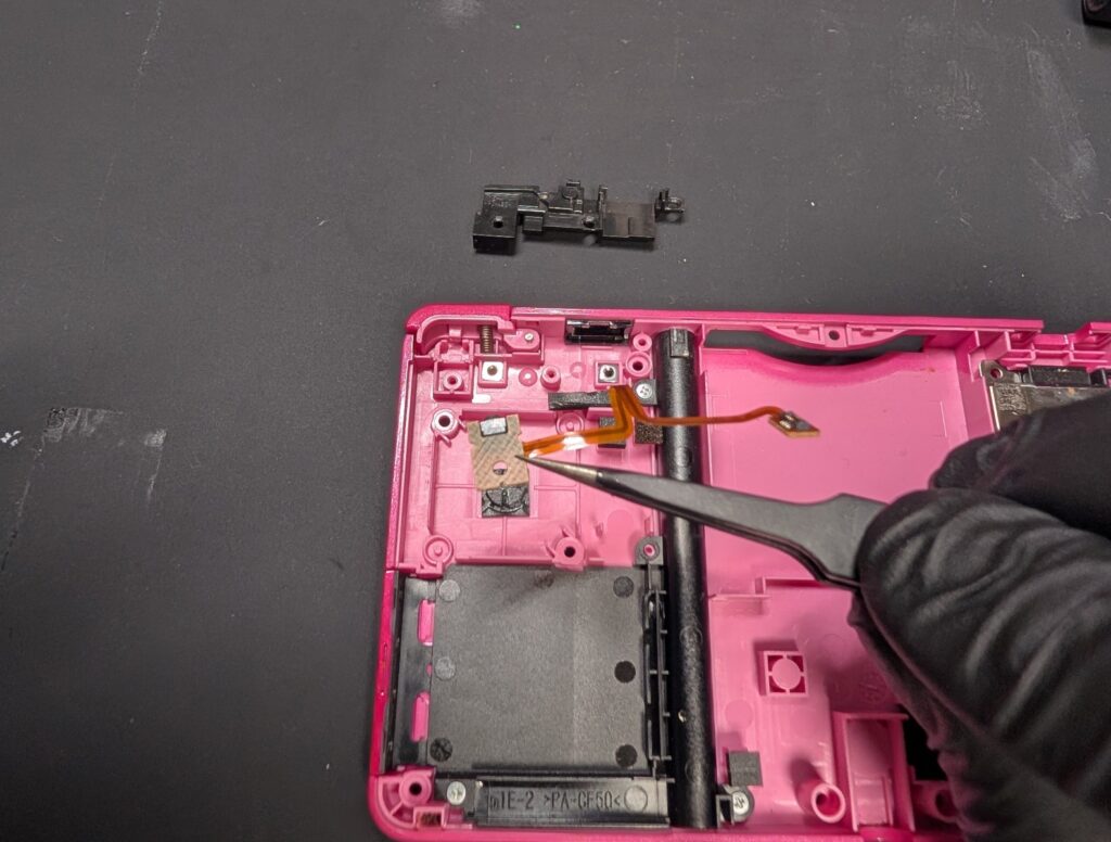 3DSのLボタン固定パーツを外した後にLボタンを交換している様子