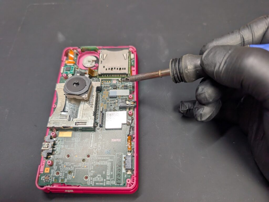 3DSのSDカードスロットの基板とハンダ付けされている部分のハンダを溶かしているときの写真