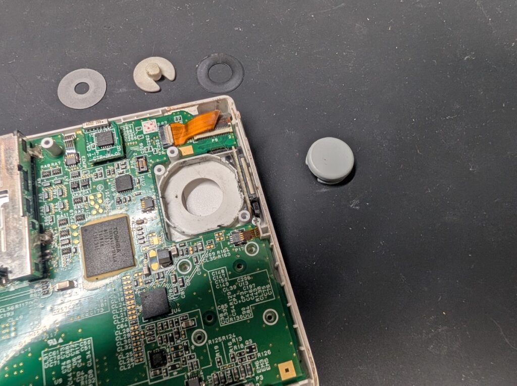 3DSLLの破損したスライドパッドと、新しいスライドパッドを比較している写真