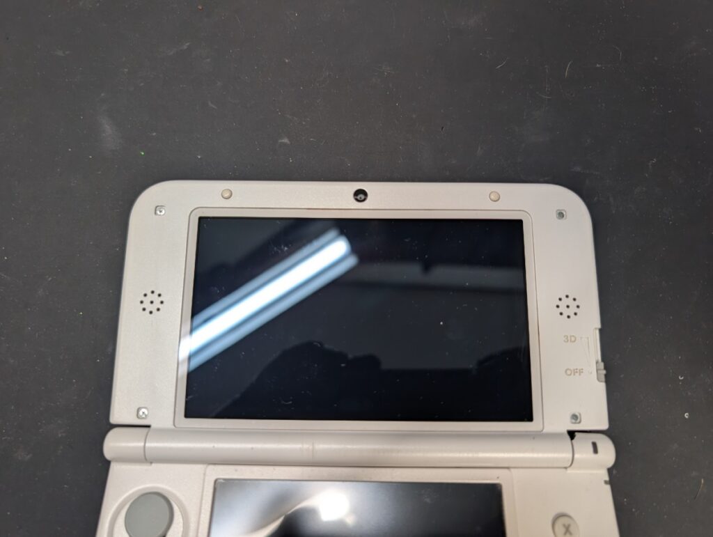 3DSLLの上画面を固定しているネジを取っているときの写真