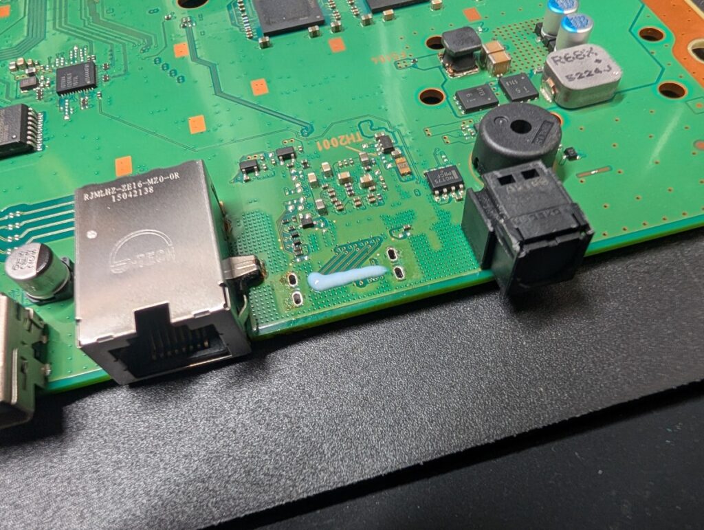CUH-1100Aの基板からHDMI端子を外して、基板に残ったハンダを除去しているときの様子