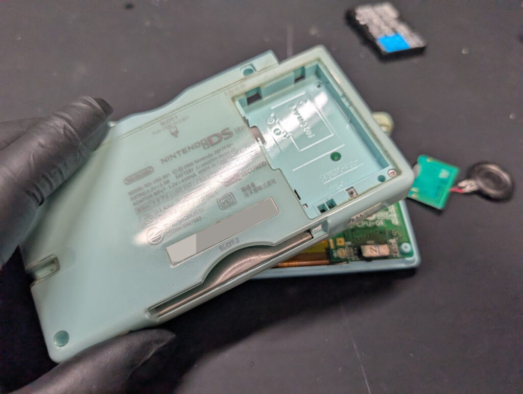 DS Liteのバッテリーカバーを取り付ける様子