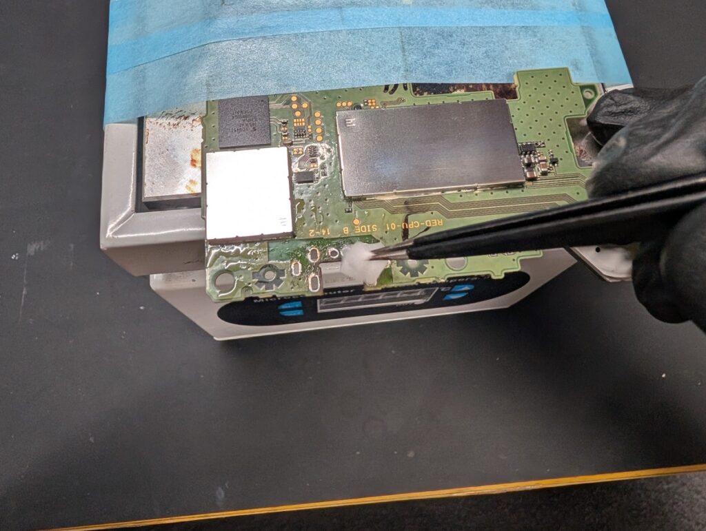 NEW3DSLLの充電ポート取り付け面を清掃しているときの写真