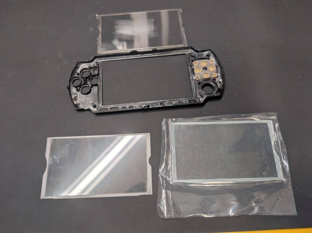 PSP-3000のプロテクターパネルの並べている写真
傷入ったパネル
ガラス製の新品パネル
樹脂製の新品パネル