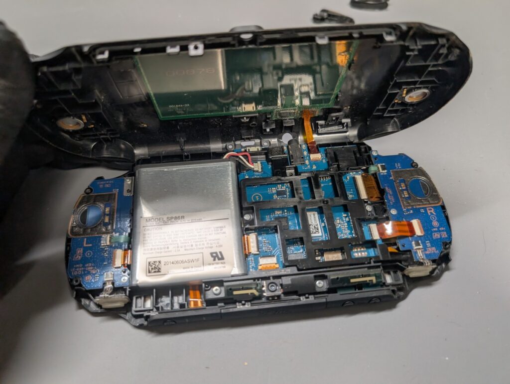 PS Vita PCH-2000の背面カバーを取り外し後にケーブルを抜いているときの写真