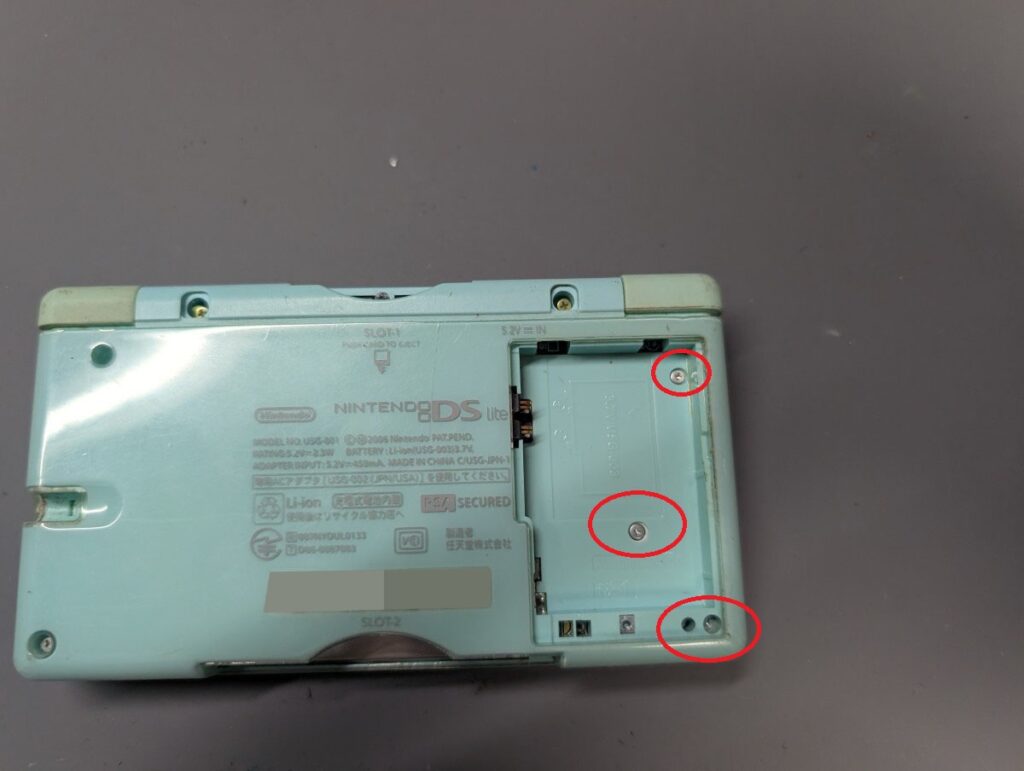 DS Liteのバッテリーを外して、その下のネジを外している写真