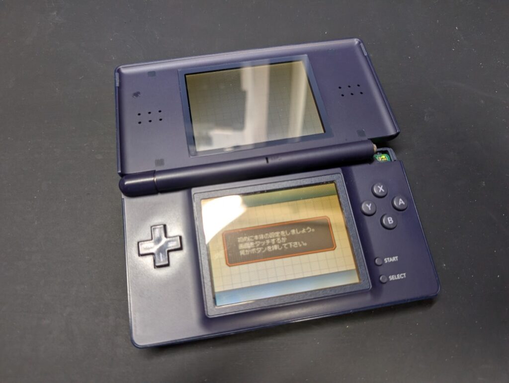 ヒンジ部が破損し、液晶に黄ばみがあるDSLiteの写真