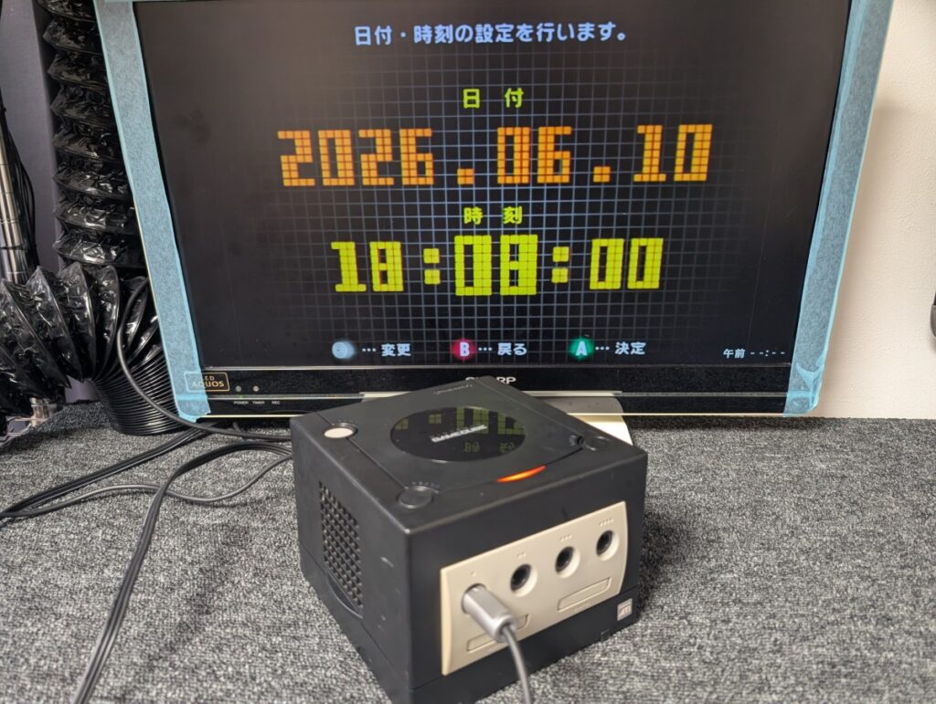 ゲームキューブの本体と日時合わせ画面が表示されたテレビの写真